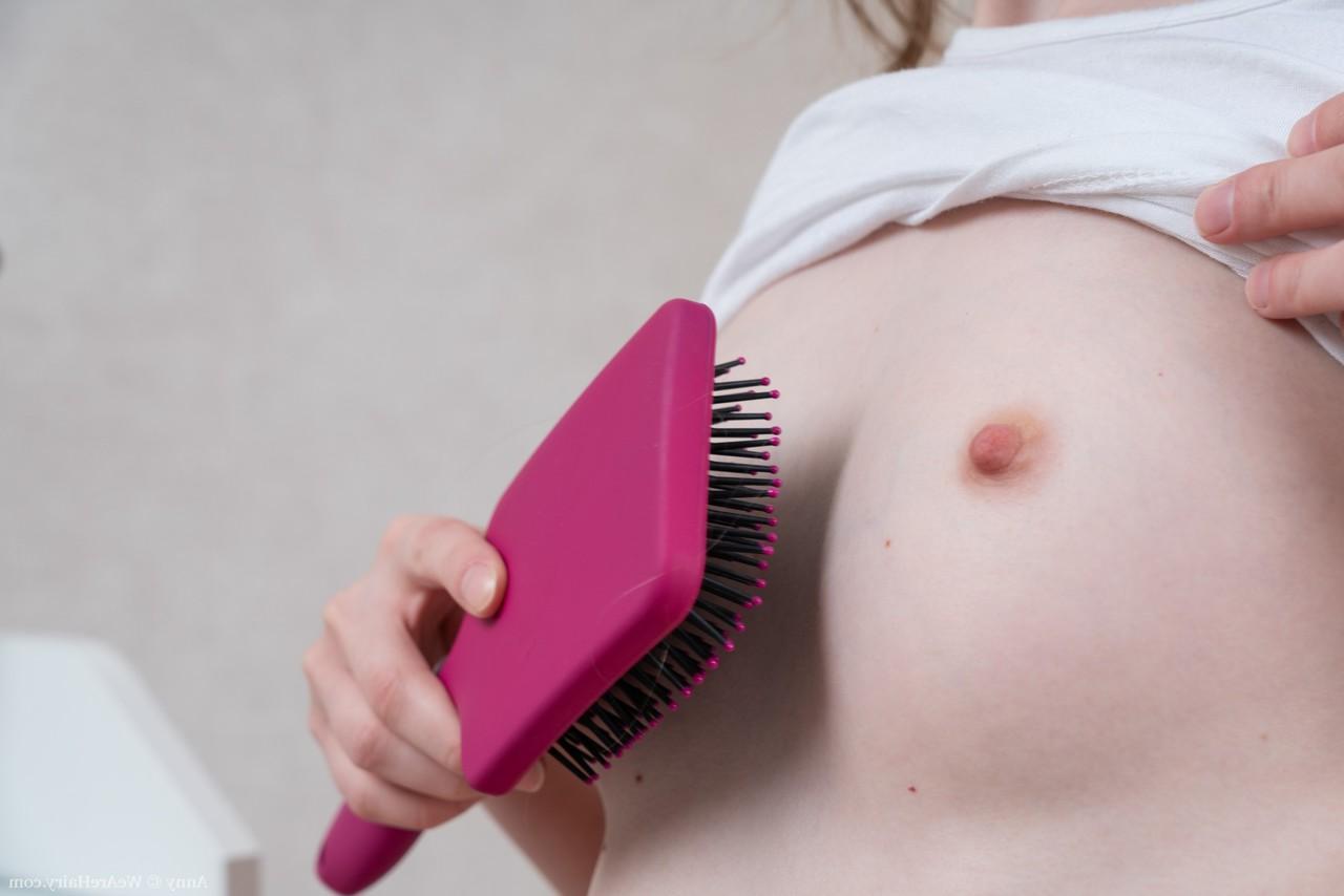 20P Anny, jeune amateur aux petits seins, se brosse les cheveux longs de la chatte en solo.