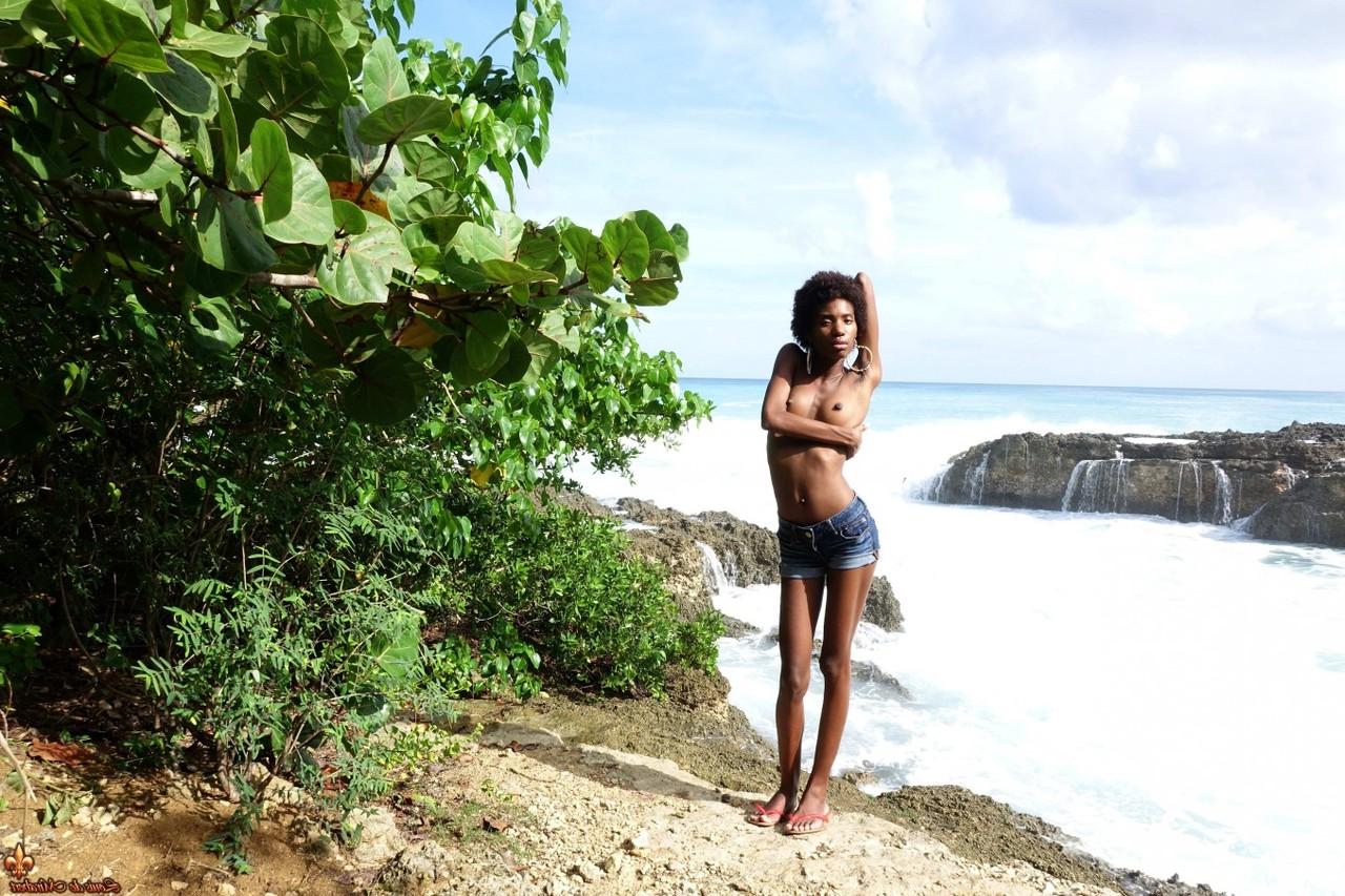 16P Ebony chick goes topless near the ocean in cut off shorts
