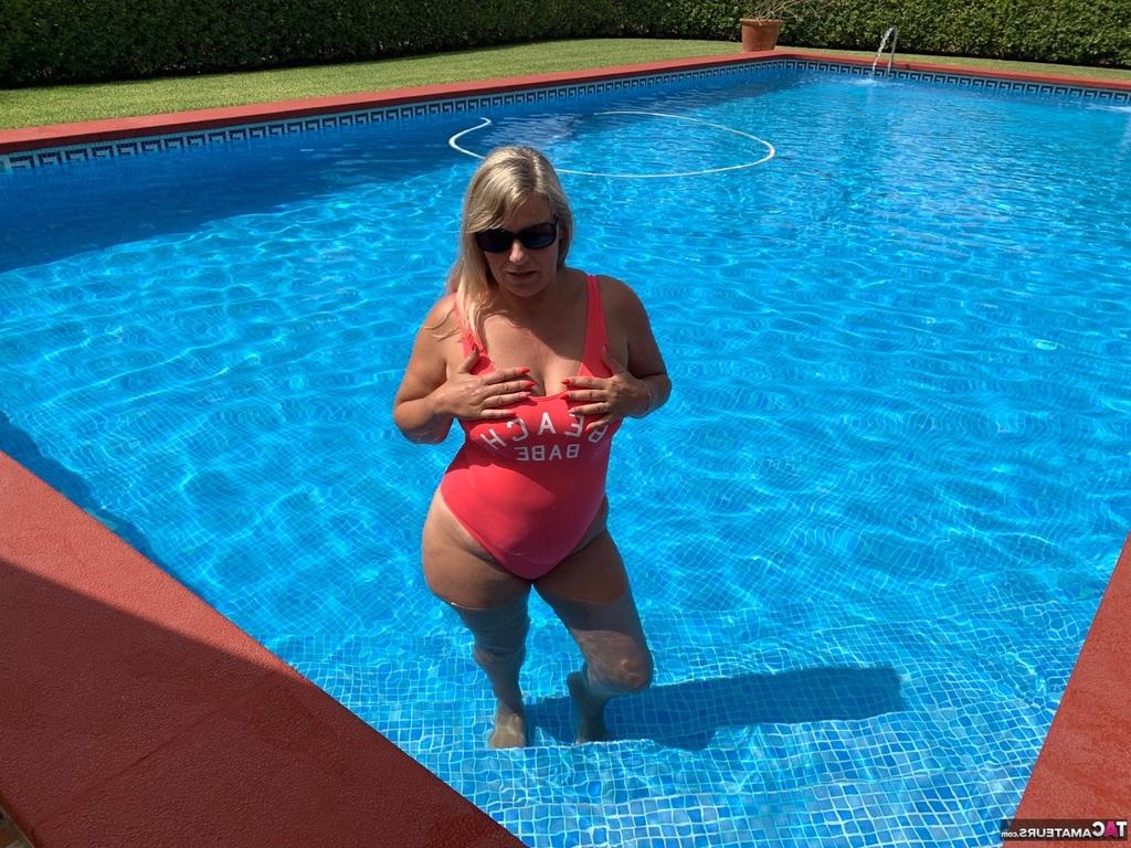 20P La blonde en surpoids Sweet Susi libère ses seins et sa chatte de son maillot de bain au bord d'une piscine.