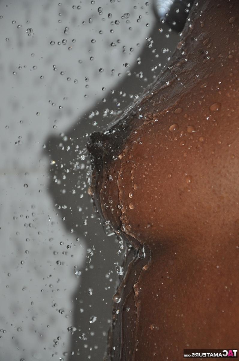 16P Fille noire aux cheveux courts montre ses seins fermes et son butin sous l'eau courante