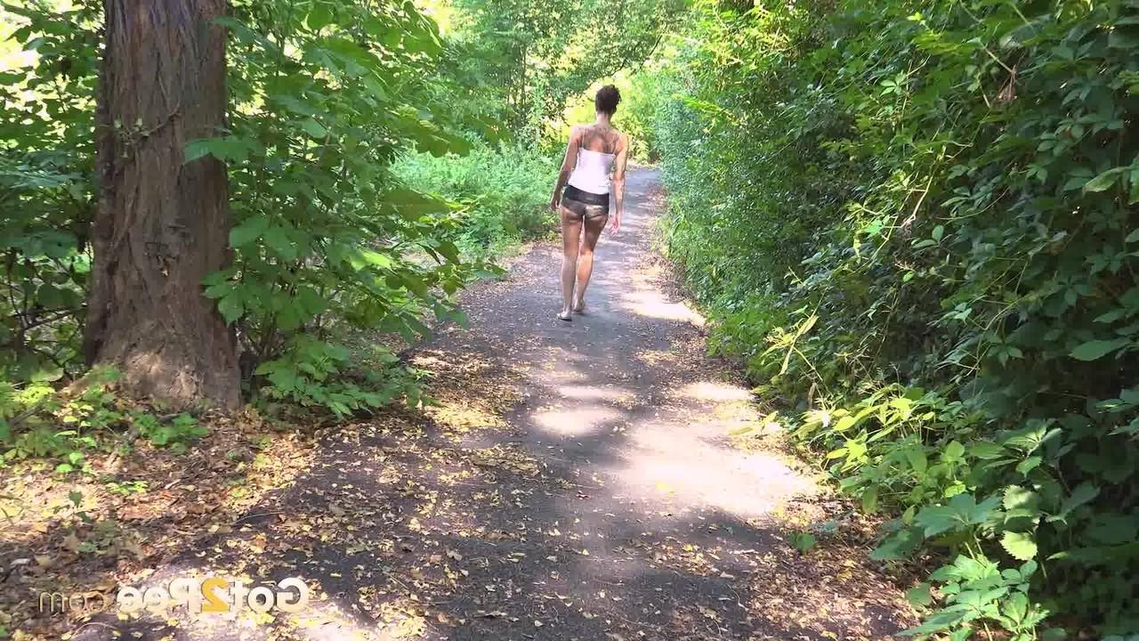 15P La chica bajita Ali Bordeaux hace pis mientras camina por un sendero en el bosque