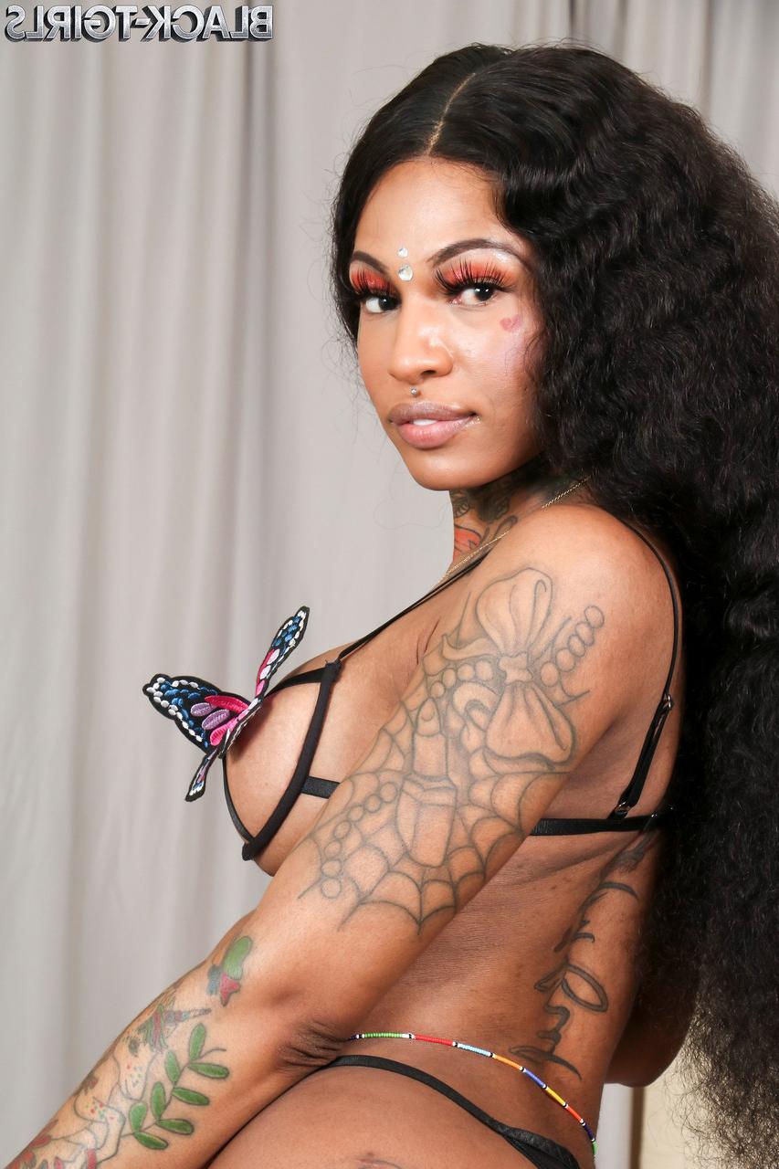 16P Baby Doll, transexuelle ébène tatouée, montre ses seins fermes et son gros cul.
