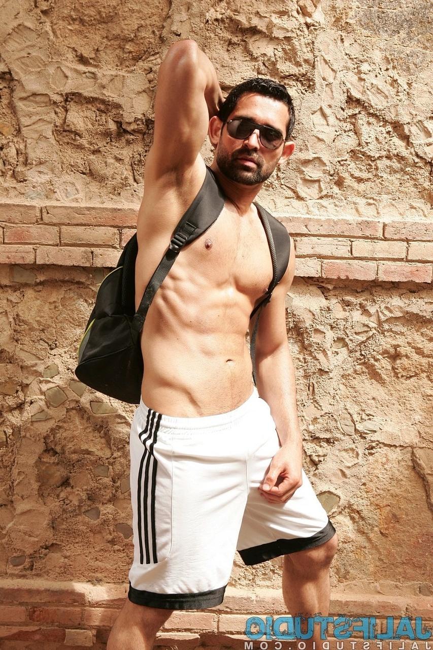 20P Dark-haired gay model Billy Baval posing naked and pissing outdoors