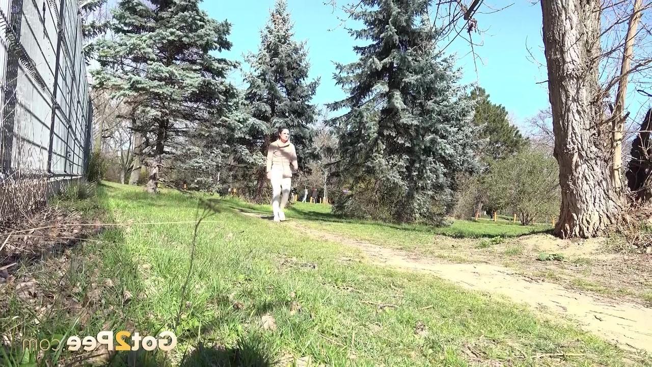 14P La chica caucásica Lara Fox se recuesta contra un árbol mientras orina