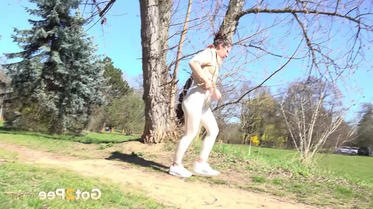 14P La chica caucásica Lara Fox se recuesta contra un árbol mientras orina