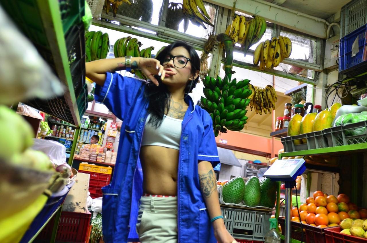 15P Une Latina tatouée tentante mange et lèche une banane de manière provocante en public