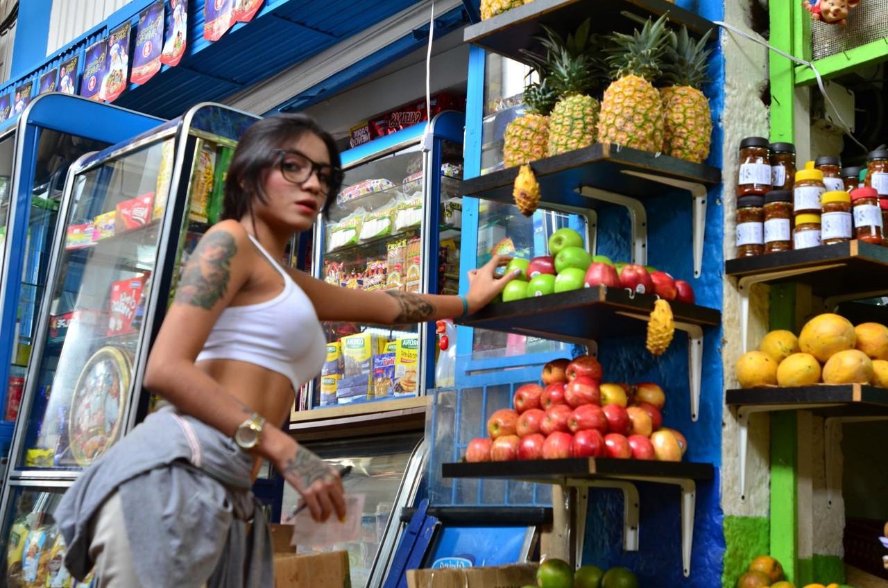 15P Une Latina tatouée tentante mange et lèche une banane de manière provocante en public