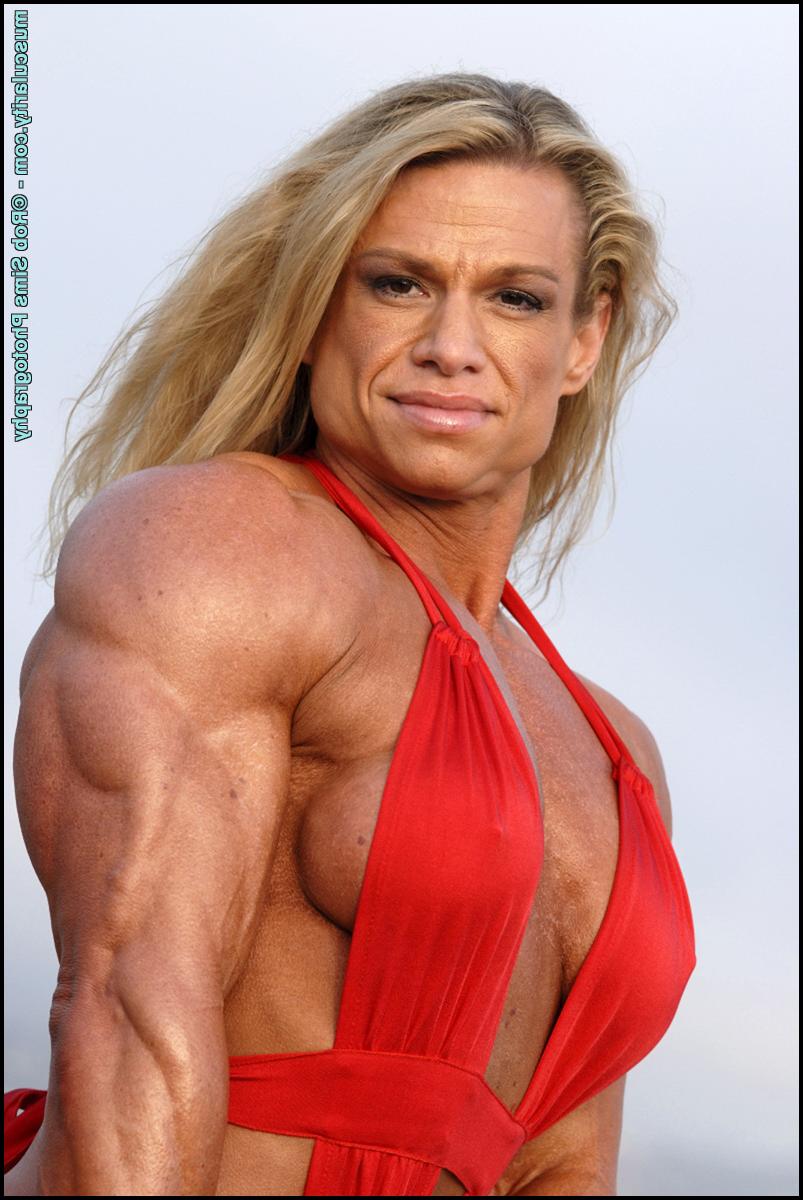15P Female bodybuilder Tina Chandler models red swimwear on a beach