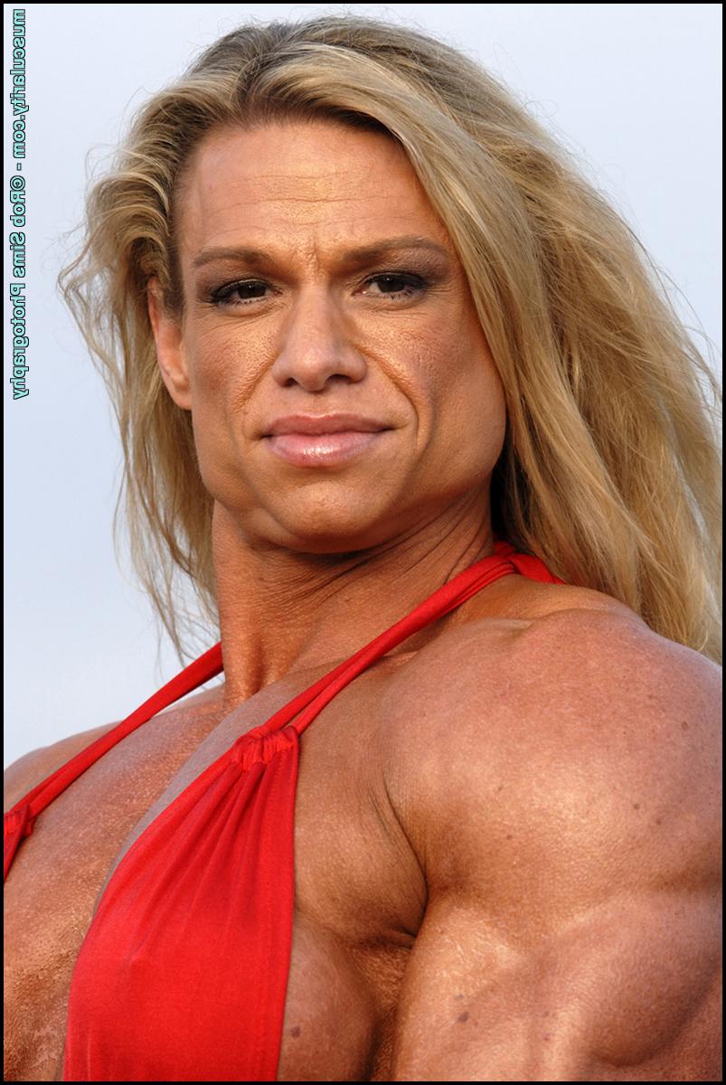 15P Female bodybuilder Tina Chandler models red swimwear on a beach
