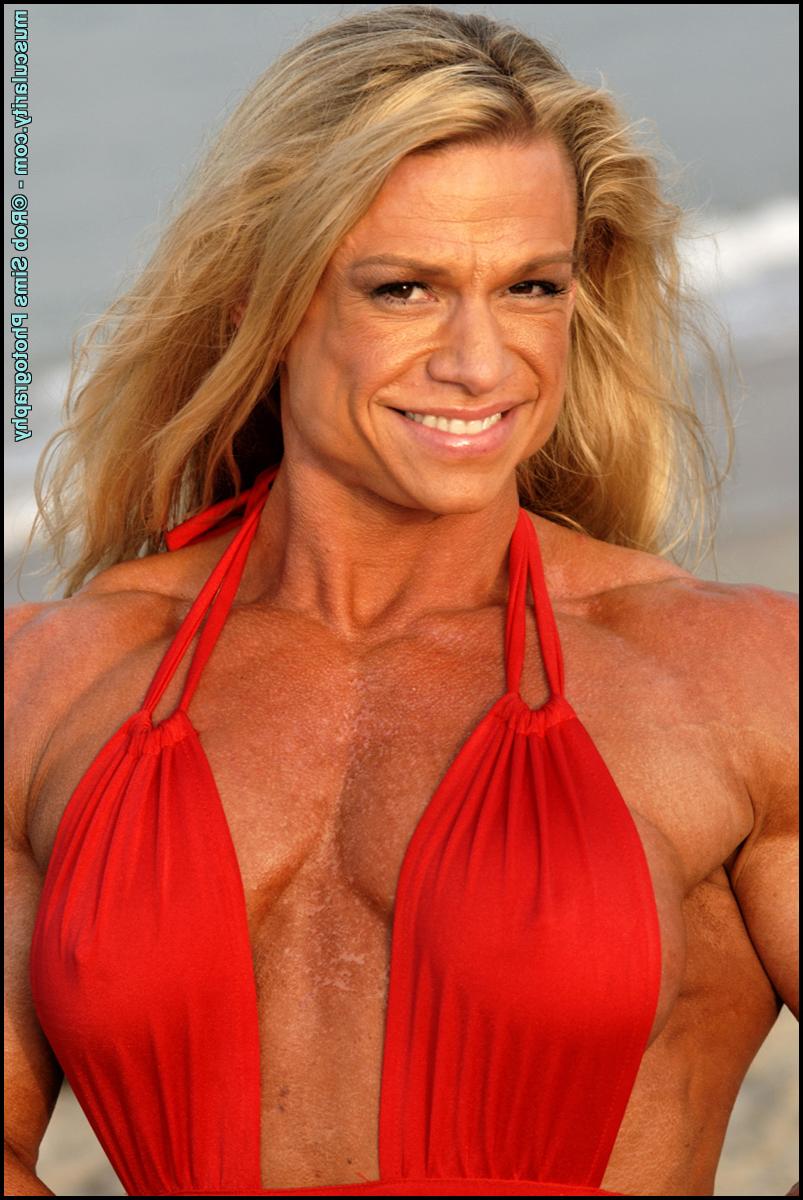 15P Female bodybuilder Tina Chandler models red swimwear on a beach