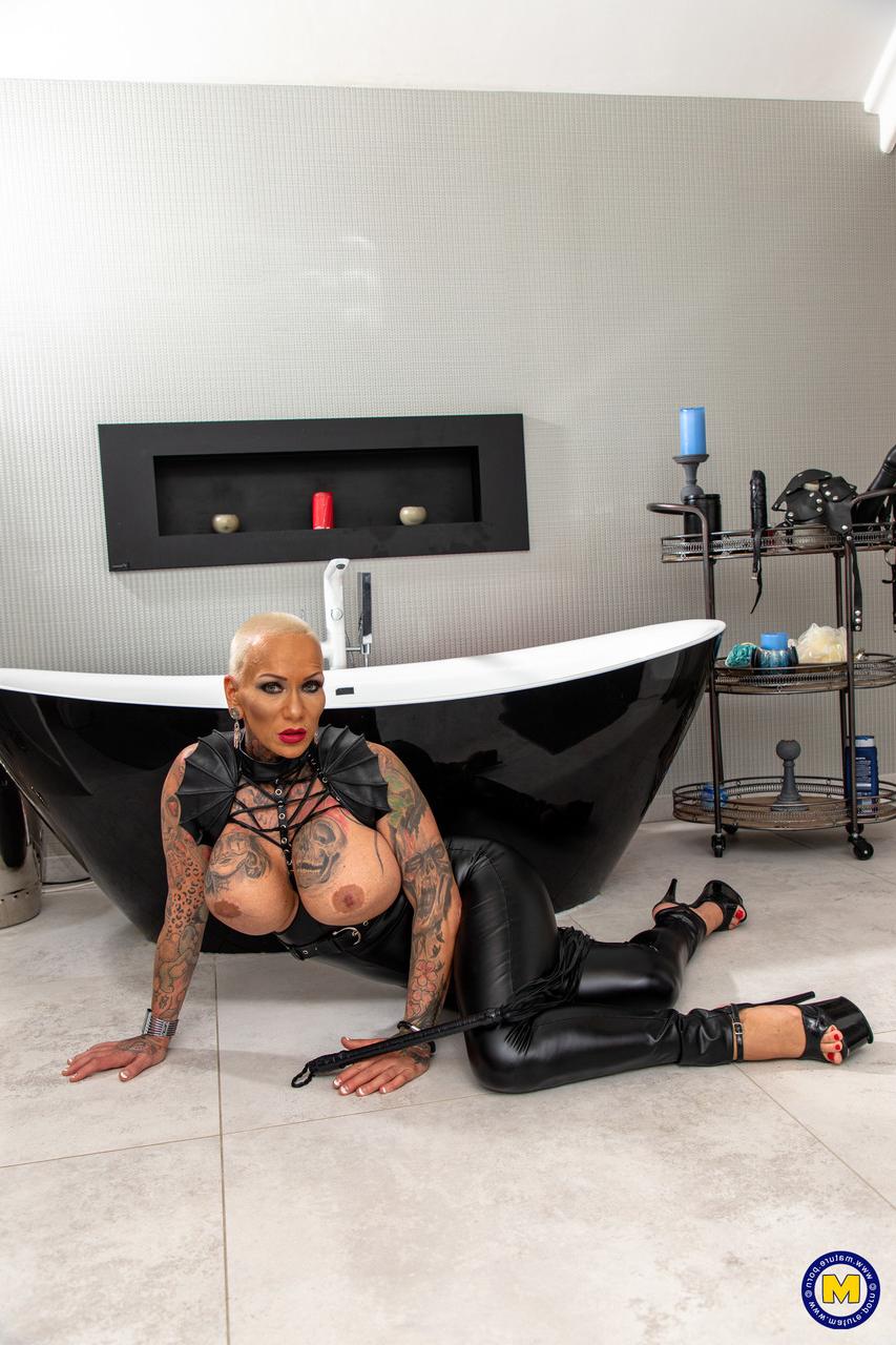 20P German MILF Kitty Core shows her big tits while posing in her leather outfit