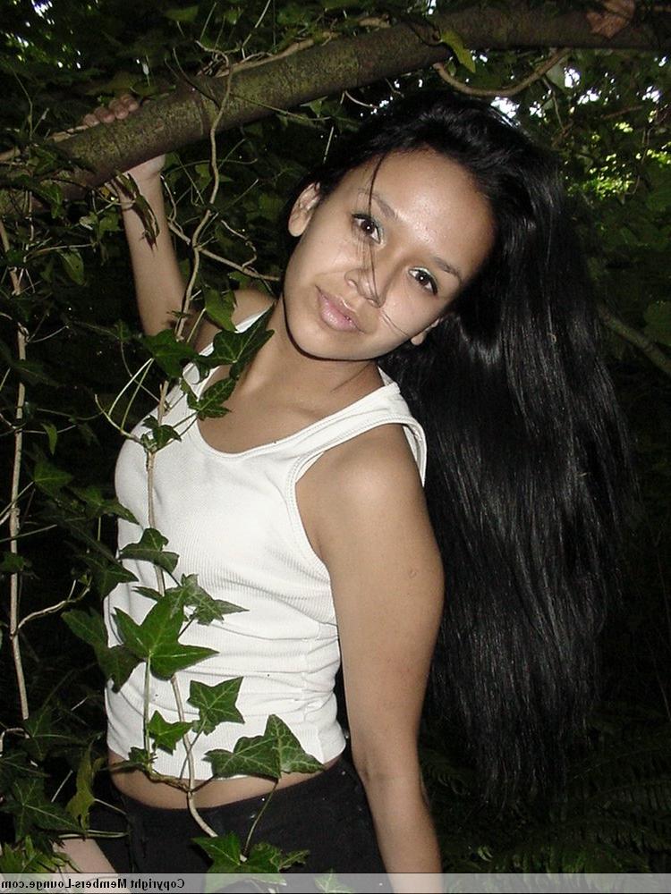 18P Pretty Indian girl hangs from a tree limb in a tank top and shorts