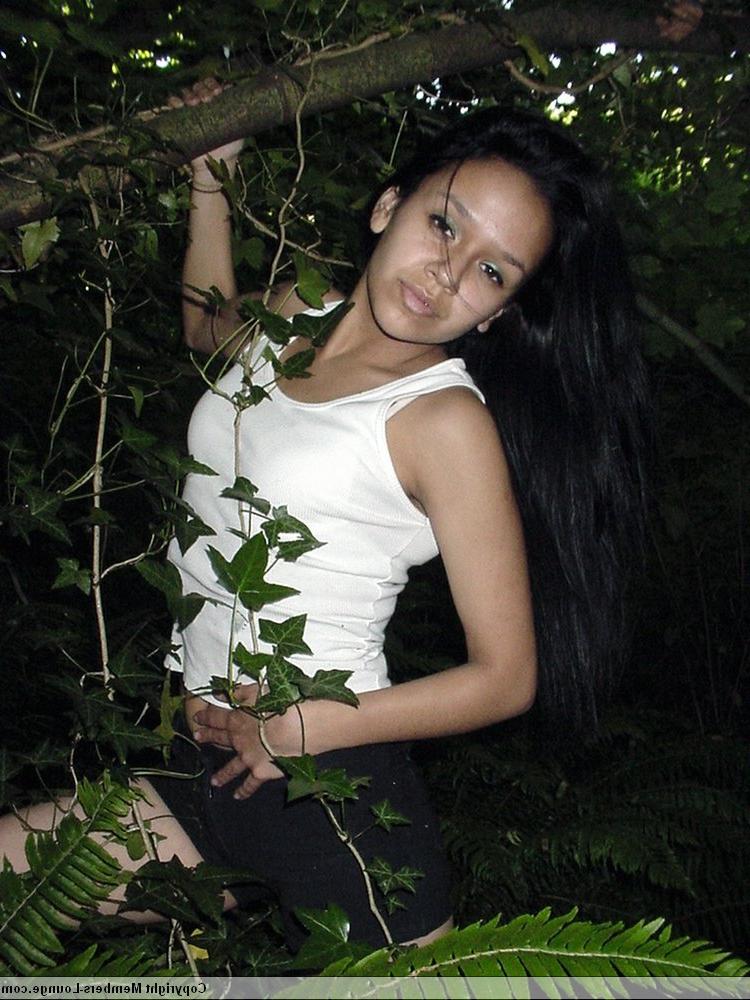 18P Pretty Indian girl hangs from a tree limb in a tank top and shorts