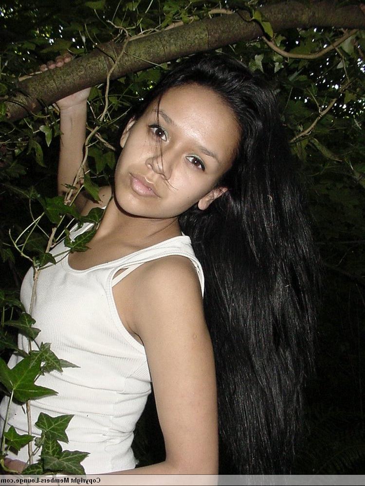 18P Pretty Indian girl hangs from a tree limb in a tank top and shorts