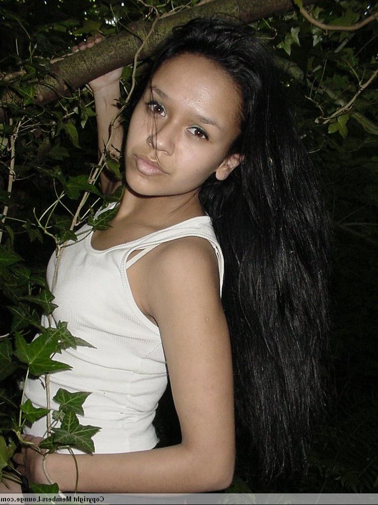 18P Pretty Indian girl hangs from a tree limb in a tank top and shorts