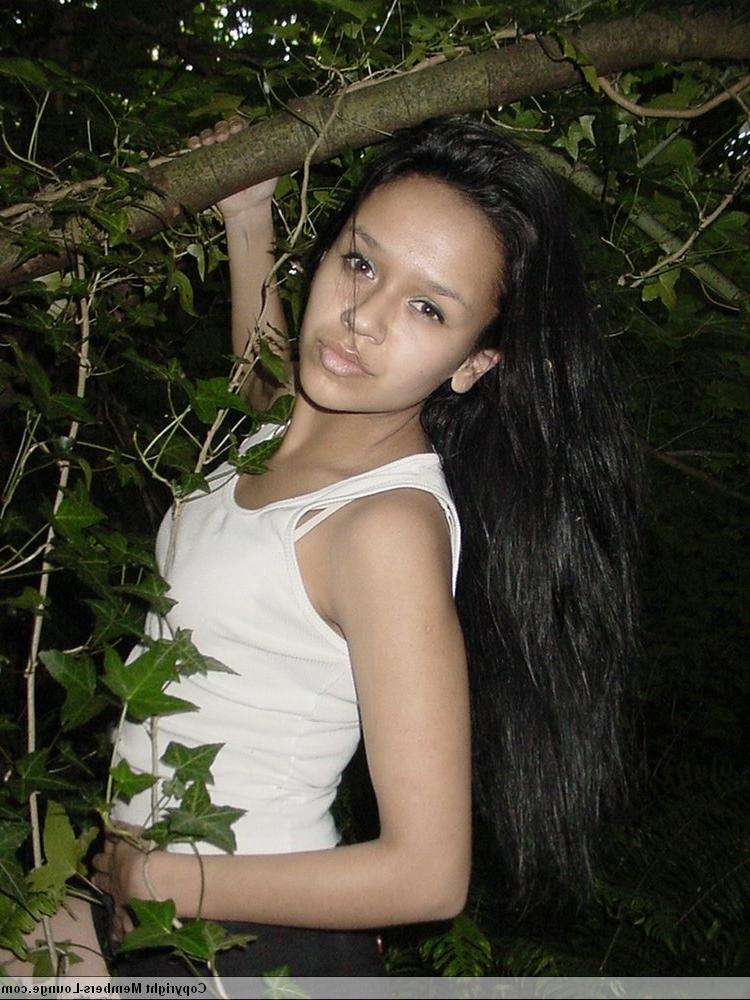 18P Pretty Indian girl hangs from a tree limb in a tank top and shorts