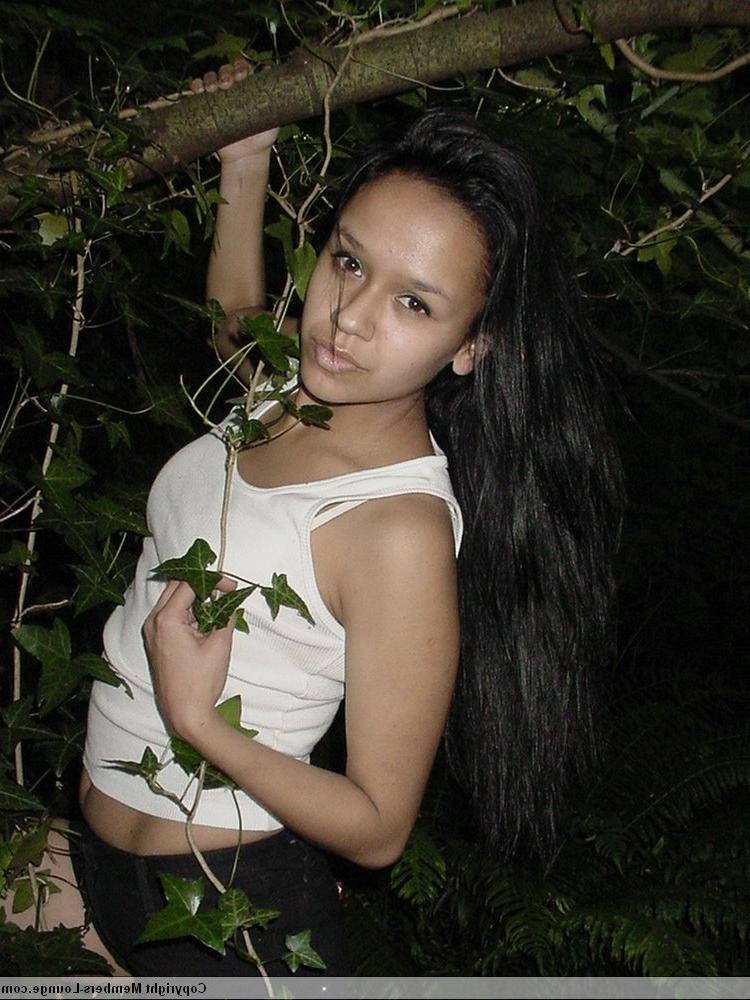 18P Pretty Indian girl hangs from a tree limb in a tank top and shorts