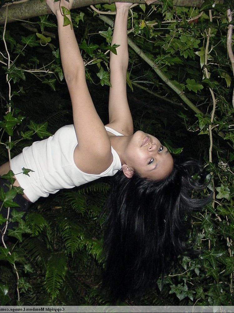 18P Pretty Indian girl hangs from a tree limb in a tank top and shorts