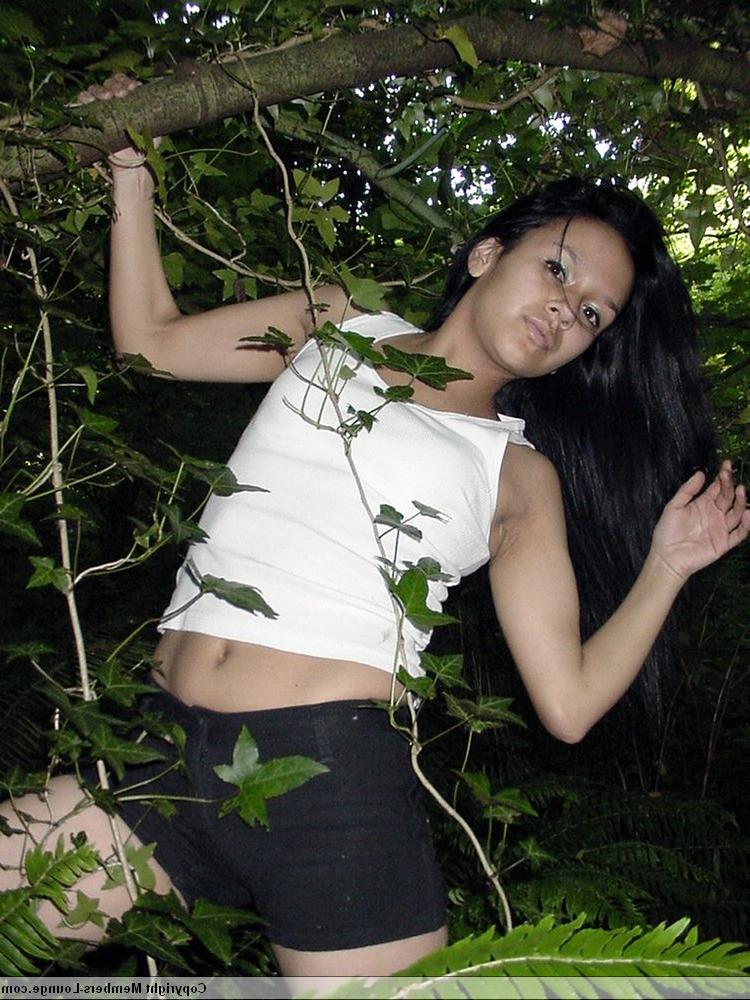 18P Pretty Indian girl hangs from a tree limb in a tank top and shorts