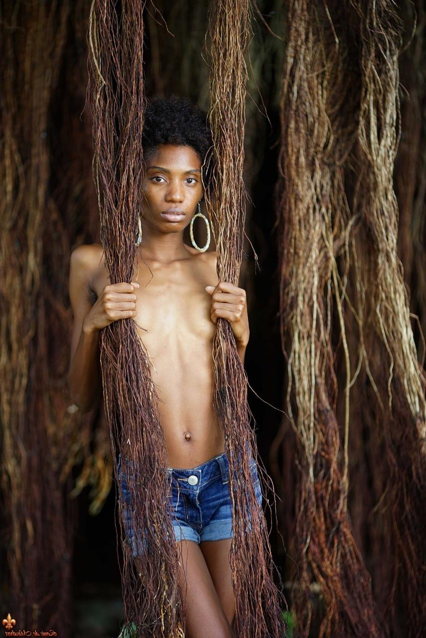 16P Jess, mannequin mince en ébène, montre ses petits seins dans un short en jean près de vignes.