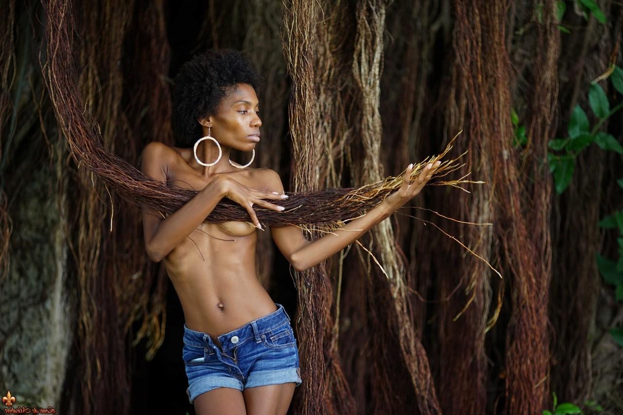 16P Jess, mannequin mince en ébène, montre ses petits seins dans un short en jean près de vignes.