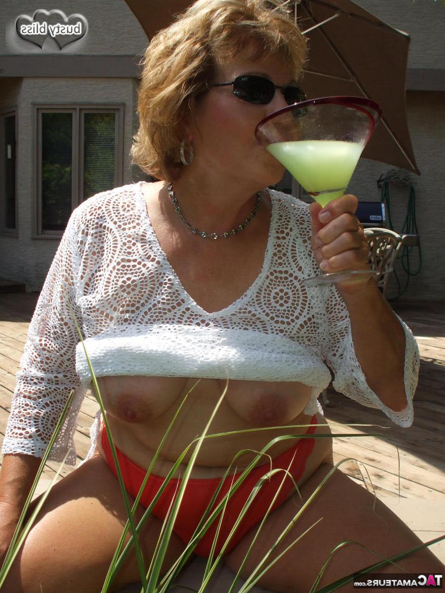 20P Mulher madura Busty Bliss expõe seus seios enquanto desfruta de uma bebida alcoólica