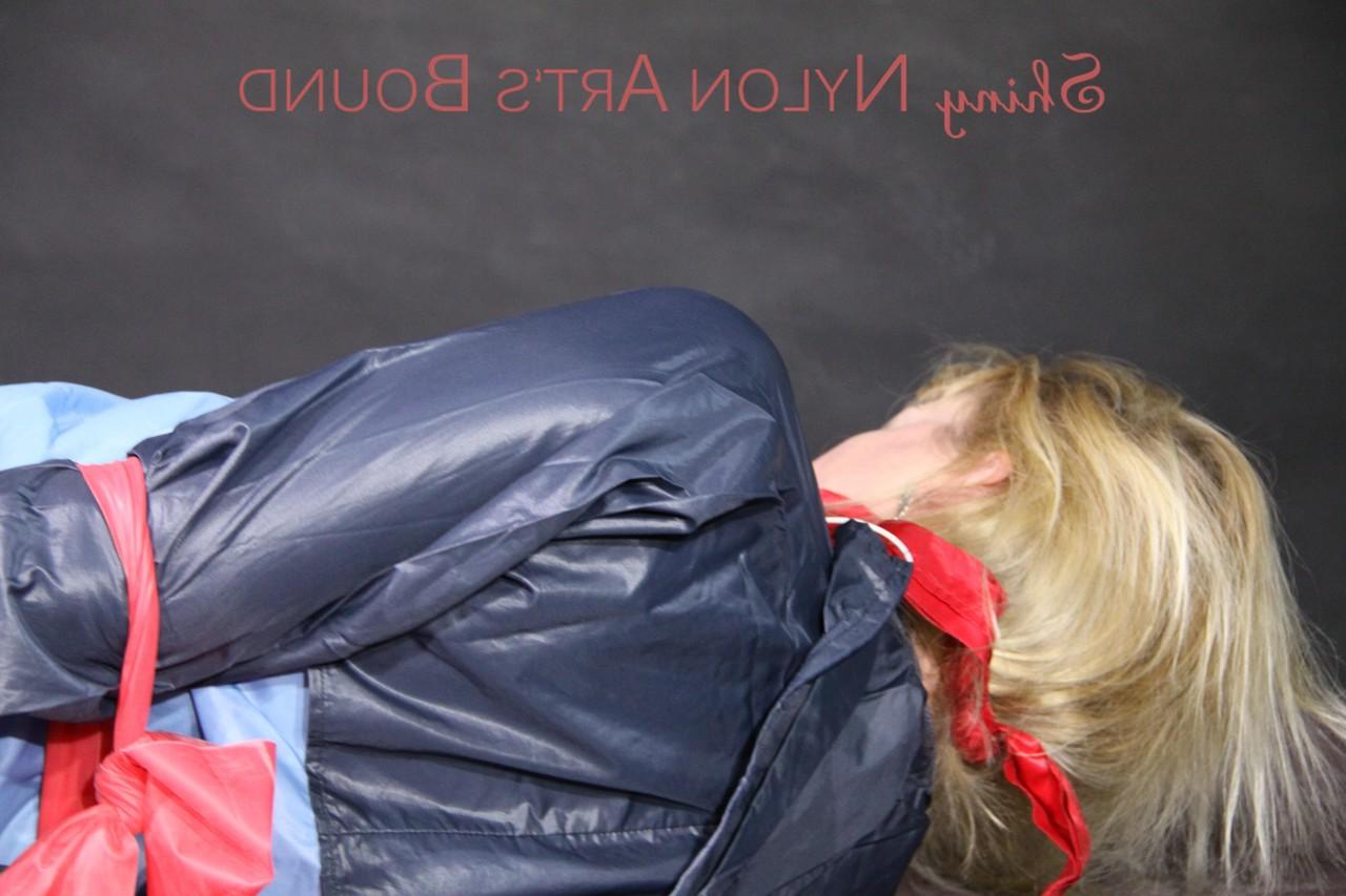 16P Chica rubia es dejada amordazada y atada con pantalones cortos de nailon y un impermeable