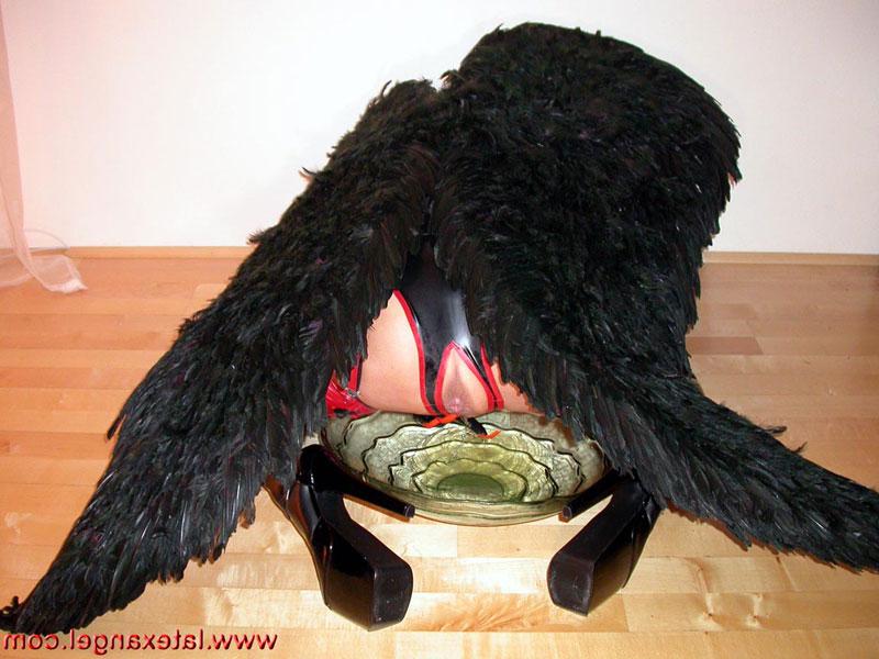 15P Redhead chick pees into a glass bowl while wearing angel wings and latex wear
