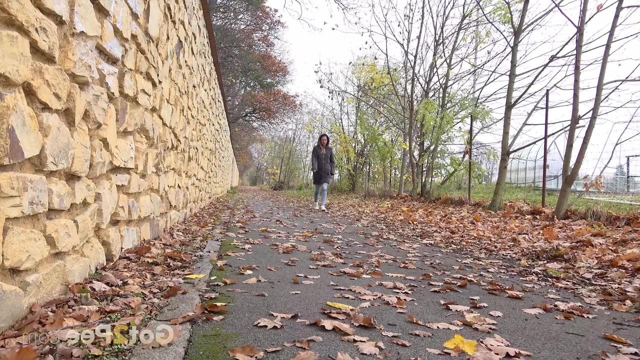 15P A branca Claudia Macc mija nas folhas caídas perto de um parque esportivo