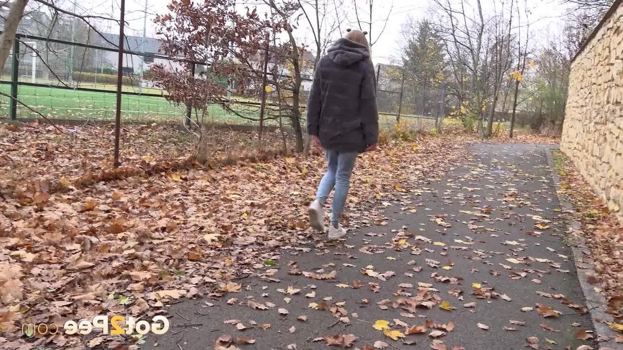 15P A branca Claudia Macc mija nas folhas caídas perto de um parque esportivo