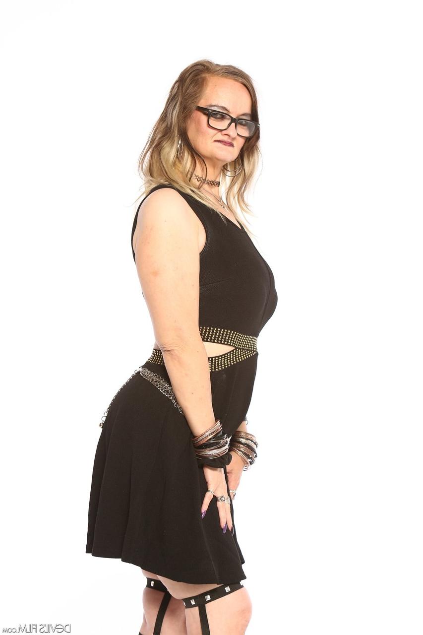 20P La star du porno mamie Lilith C enlève sa robe noire pour des poses nues avec des bottes.