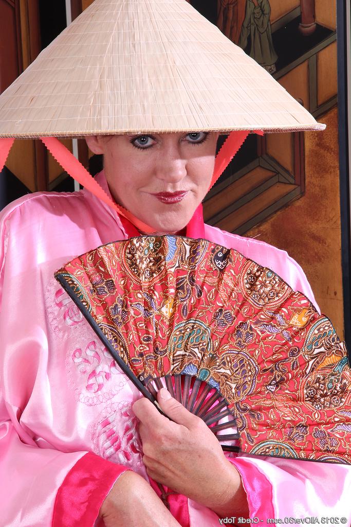 16P Mulher madura Shauna fica com sapatos pretos diante de uma tela oriental