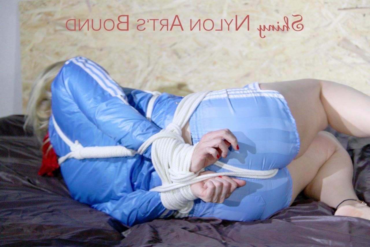 16P Blonde chick is left hog tied and gagged in a nylon coat and matching shorts