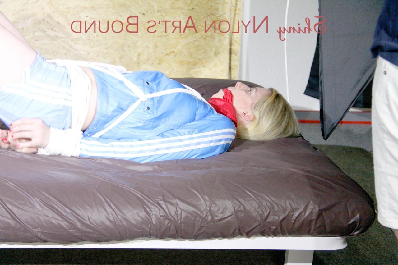 16P Blonde chick is left hog tied and gagged in a nylon coat and matching shorts