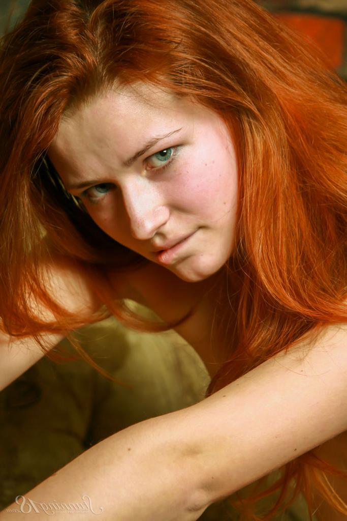 16P Young redhead Lollia Q models totally naked on a sofa in an alluring manner