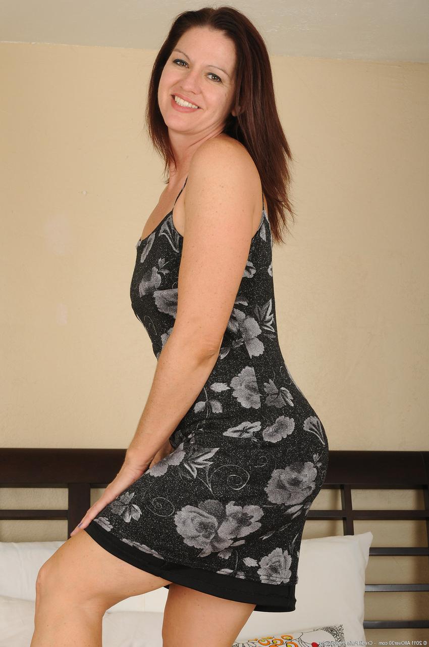 20P Hot MILF Xena spreads her trimmed pussy in a sexy striptease on her bed