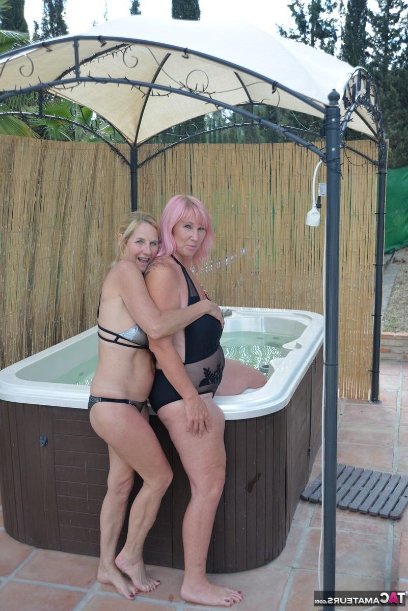 20P Melody, une lesbienne d'âge moyen, et sa petite amie s'embrassent dans un bain à remous extérieur.