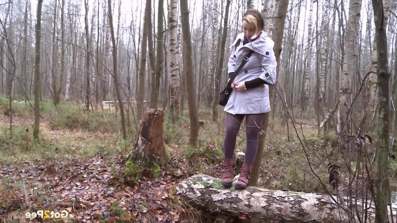 15P Clothed girl Anya pulls down tights on a log to pee into a stream in the woods