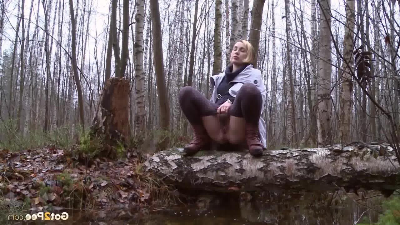 15P Clothed girl Anya pulls down tights on a log to pee into a stream in the woods