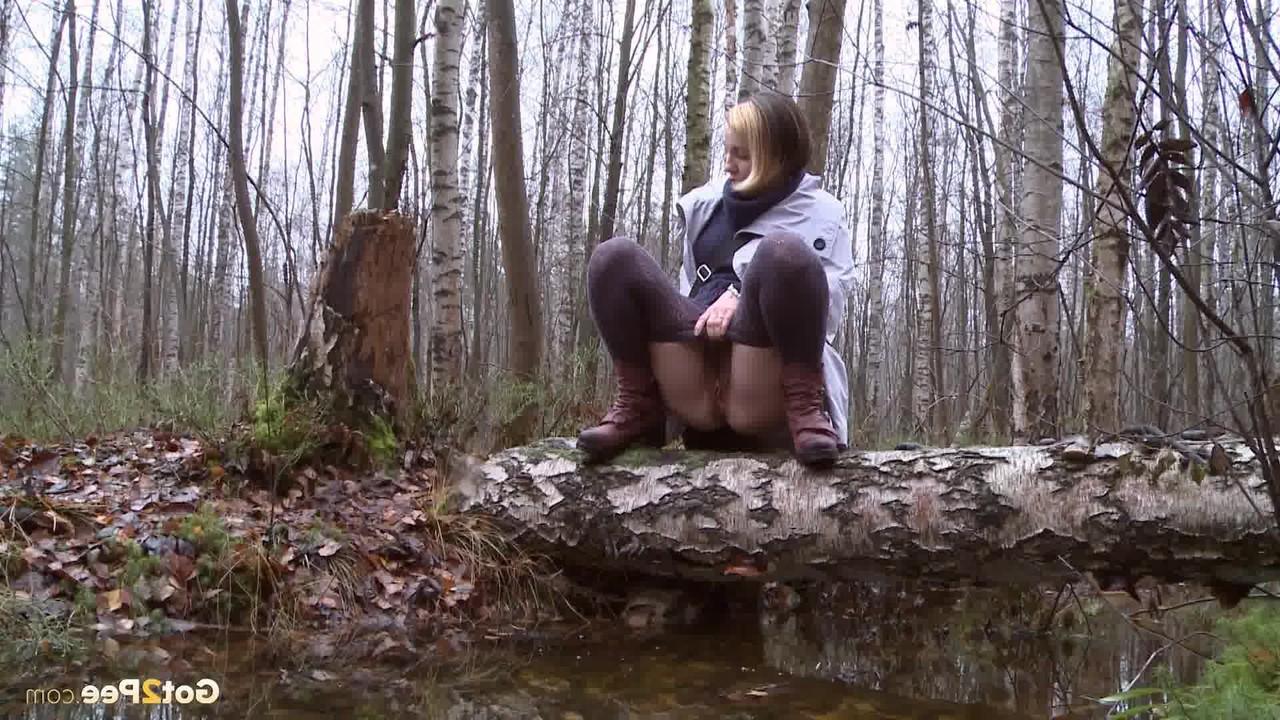 15P Clothed girl Anya pulls down tights on a log to pee into a stream in the woods