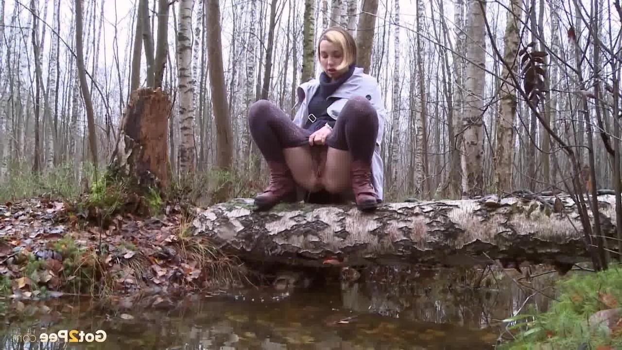 15P Clothed girl Anya pulls down tights on a log to pee into a stream in the woods