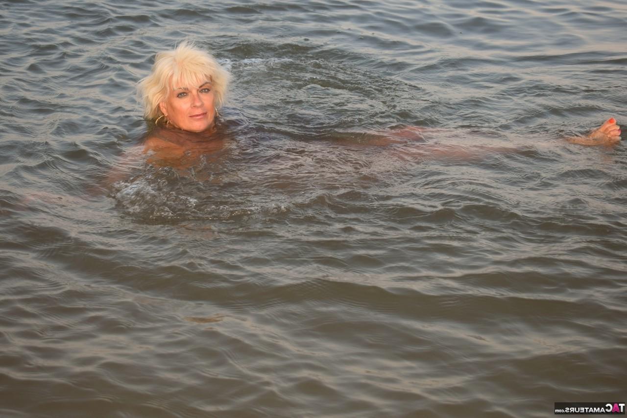 16P La rubia mayor Dimonty se desnuda completamente mientras nada en el océano