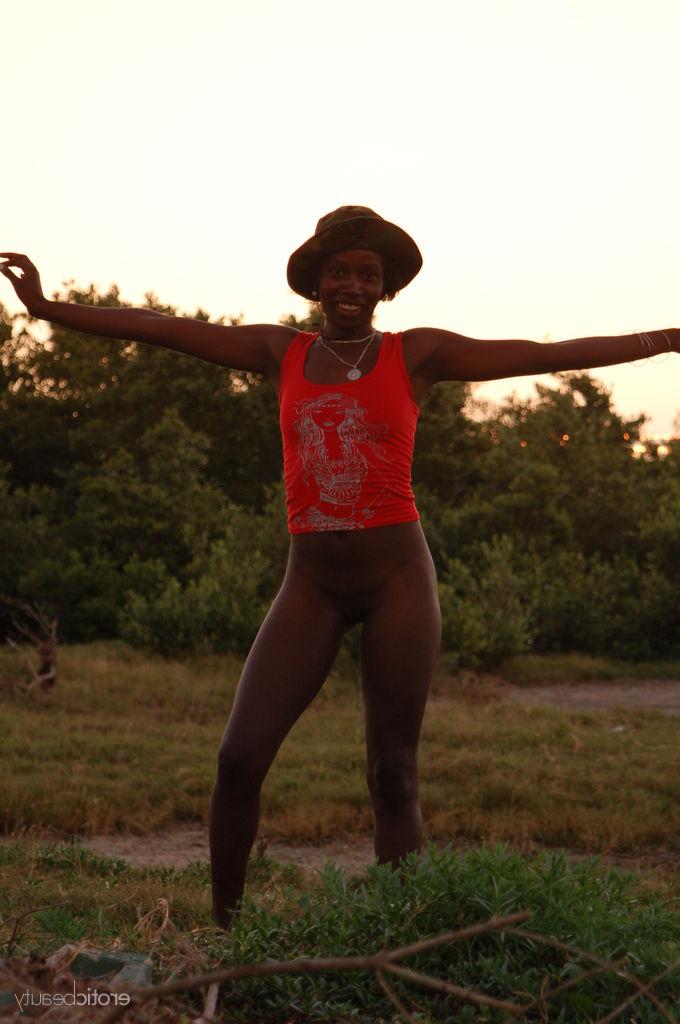 16P A negra Maria L exibe o corpo nu em um campo perto do mar