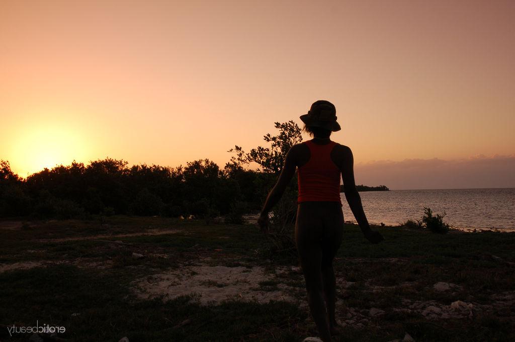 16P A negra Maria L exibe o corpo nu em um campo perto do mar