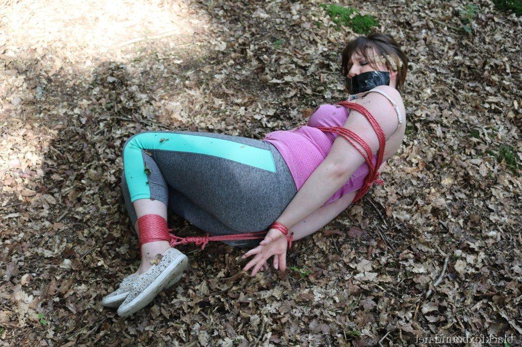 16P Caucasian girl is hogtied and gagged in her clothes upon dried leaves