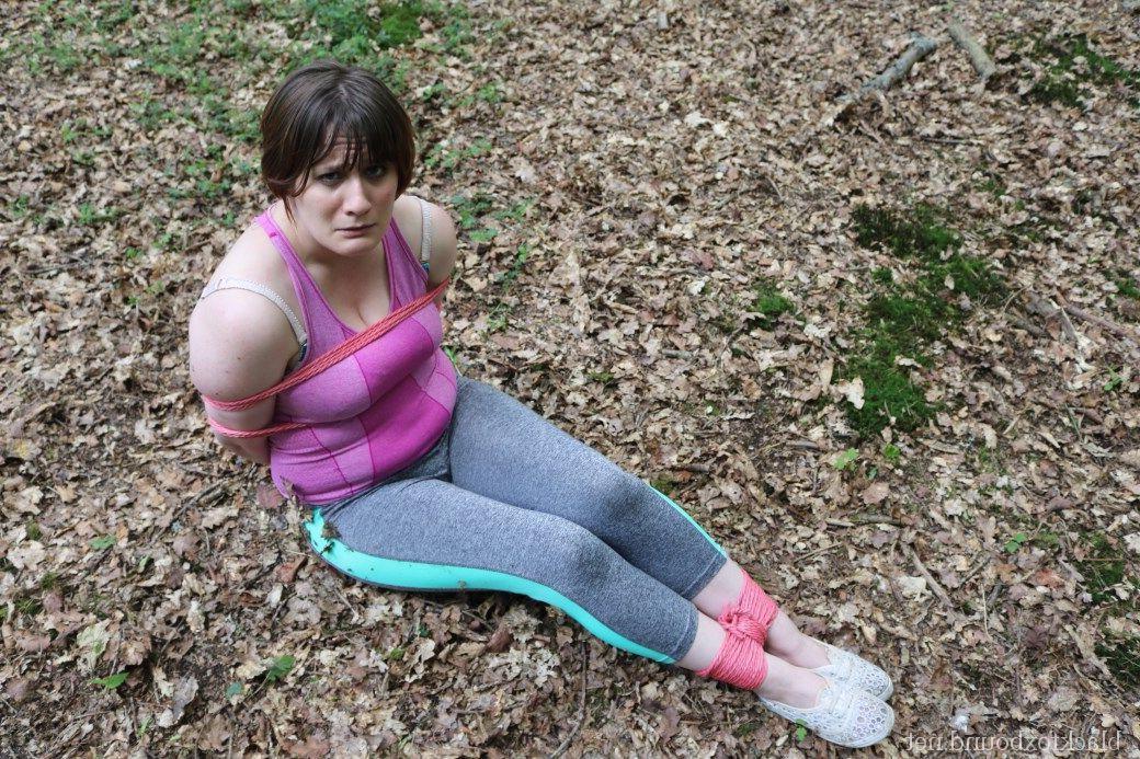 16P Caucasian girl is hogtied and gagged in her clothes upon dried leaves