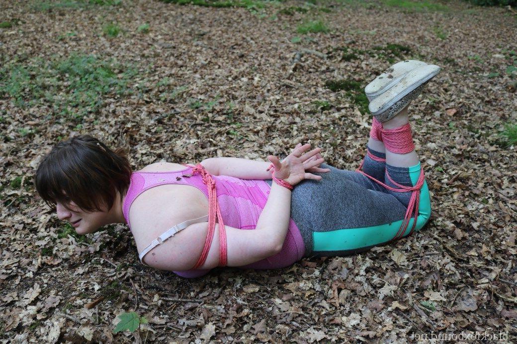 16P Caucasian girl is hogtied and gagged in her clothes upon dried leaves
