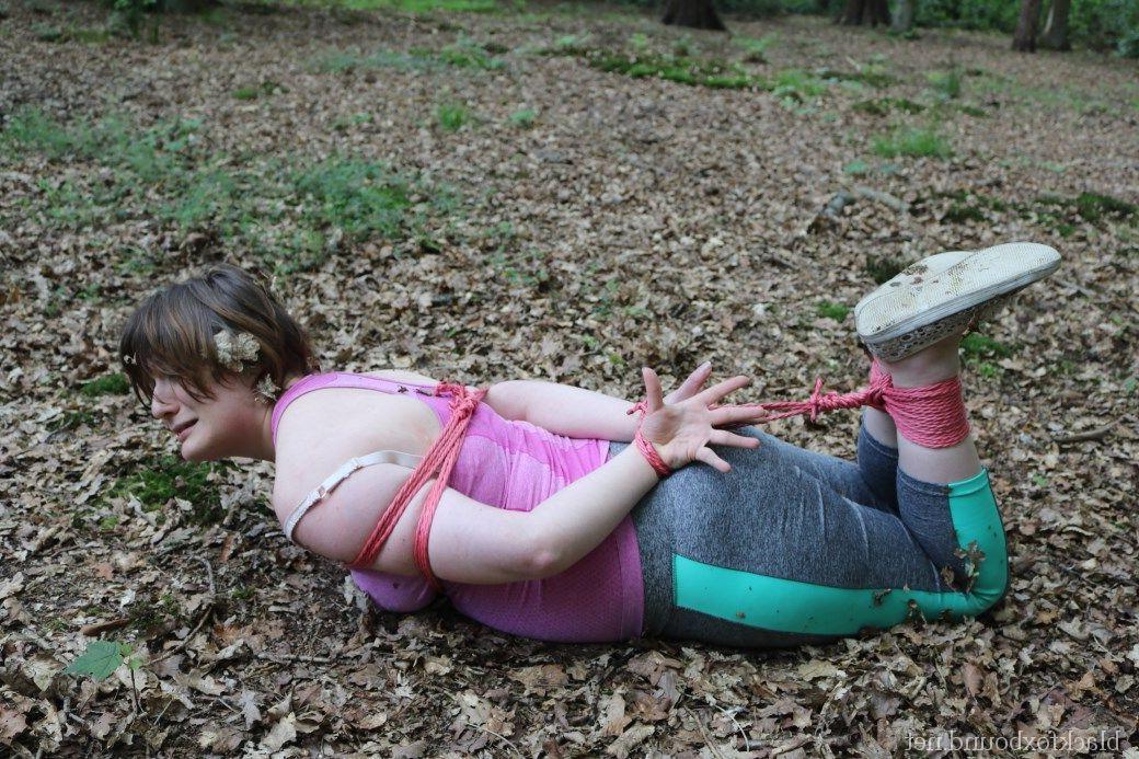16P Caucasian girl is hogtied and gagged in her clothes upon dried leaves