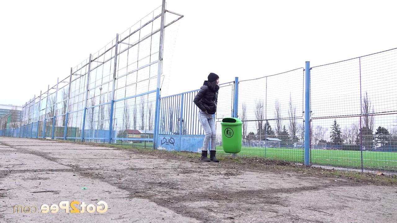15P A garota branca Mistica mija perto de uma cerca em um local público