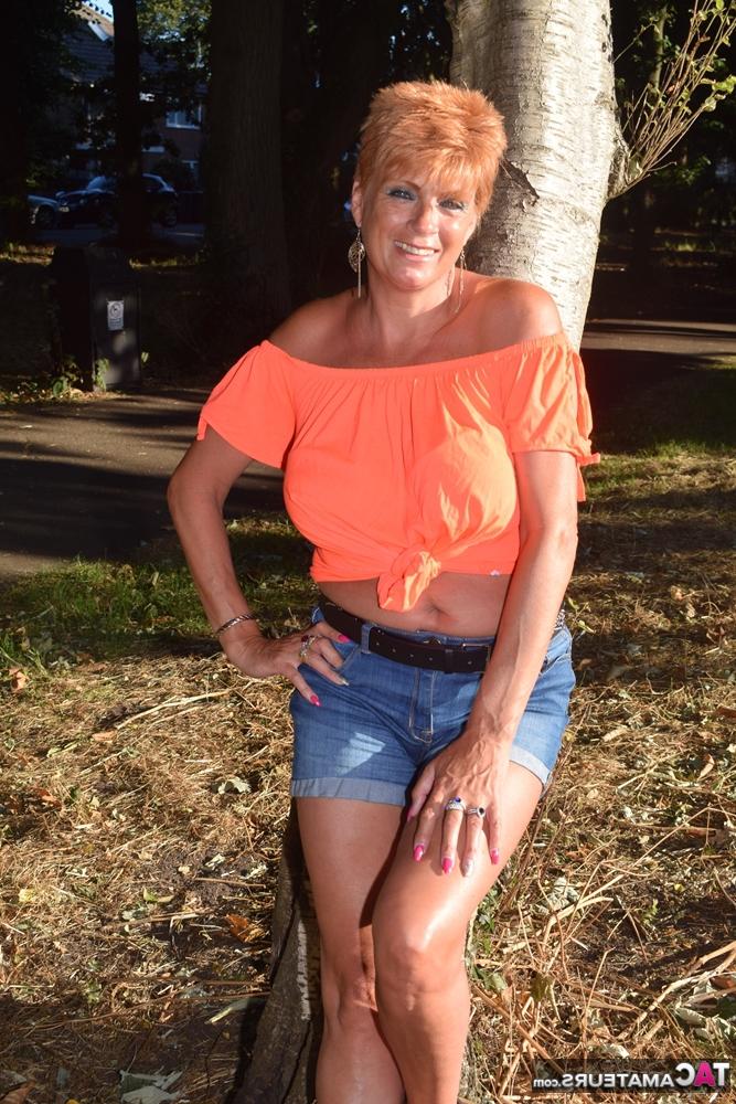 20P La madura pelirroja Dimonty muestra sus tetas en un banco de un campo rural